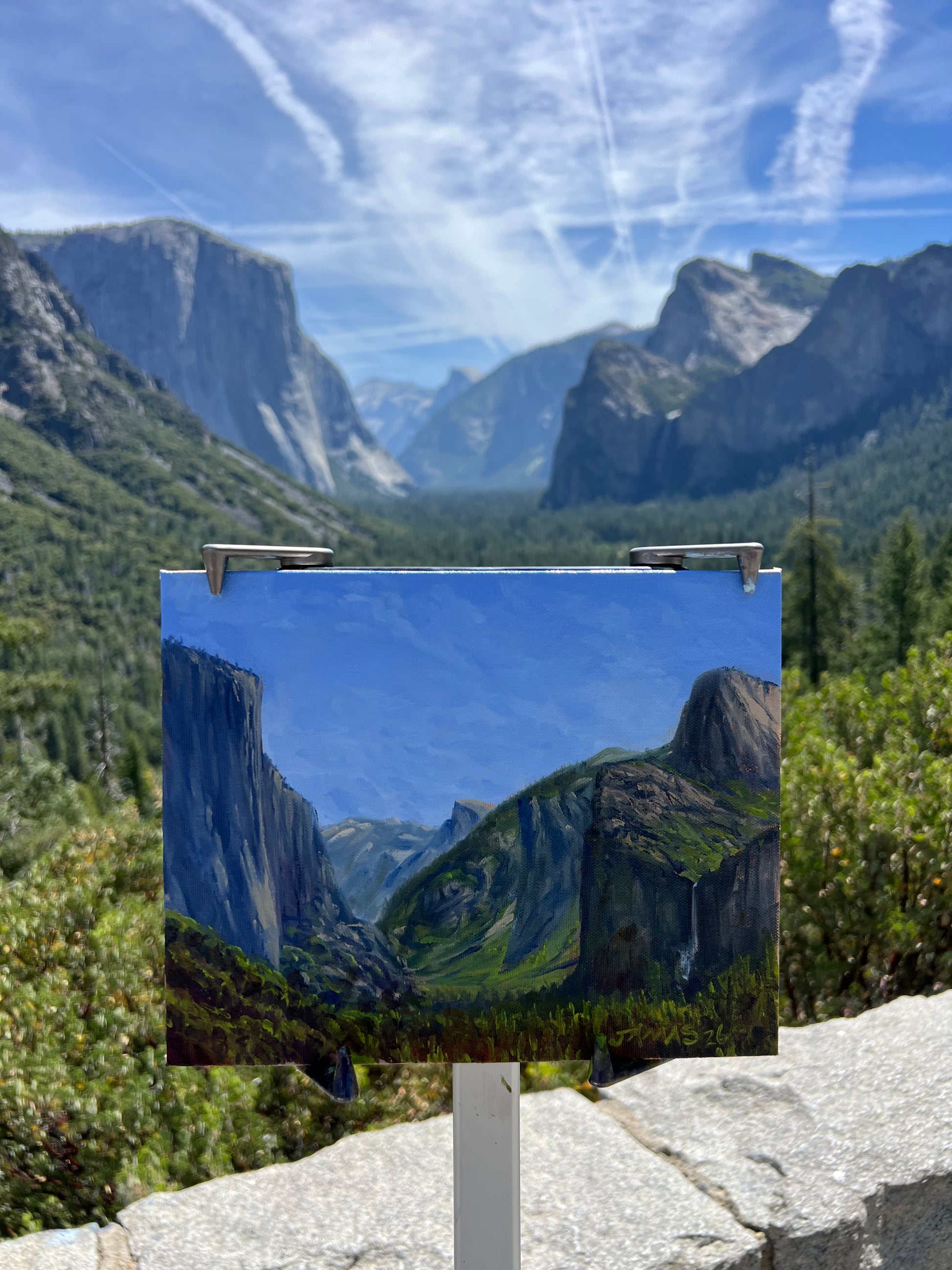 Tunnel View at Noon plein air oil painting at Yosemite, shown on easel with the actual valley view behind it
